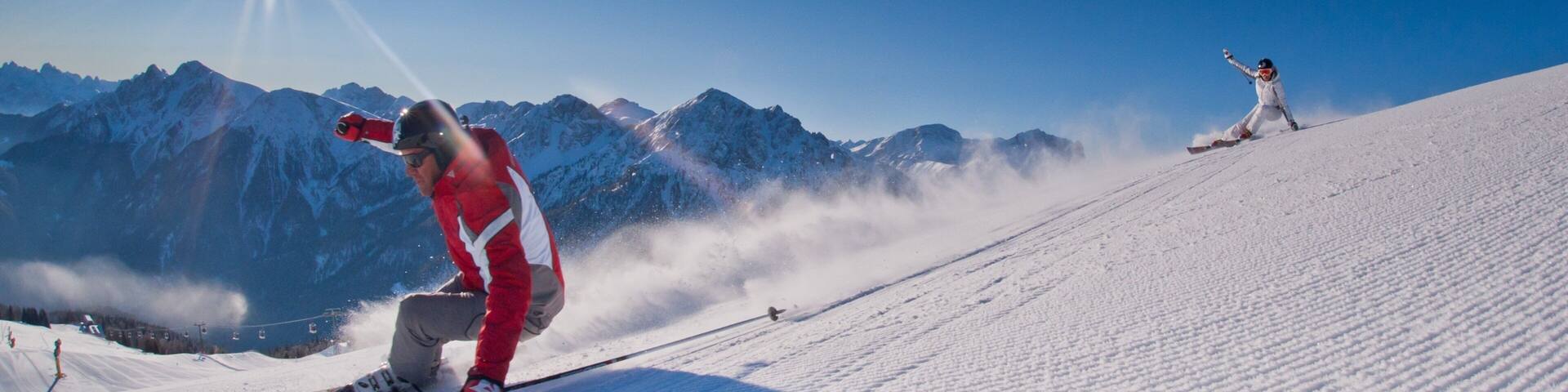 Skigebiet Kronplatz das einen Skifahren und Schnee sowie kleine Menschengruppe
