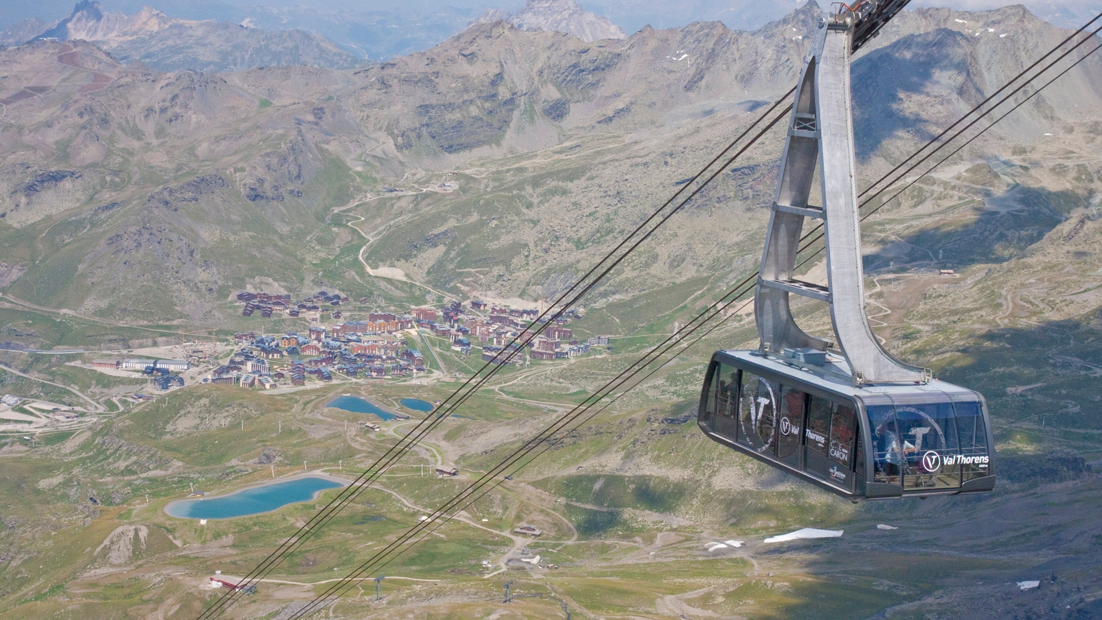 A cable car system in a mountainous area with a town below.