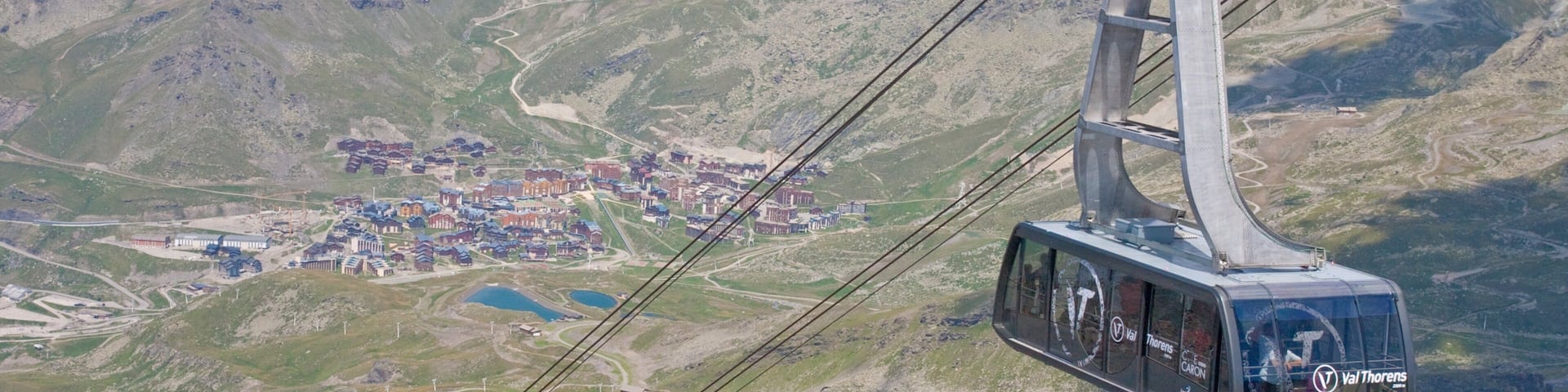 A cable car system in a mountainous area with a town below.