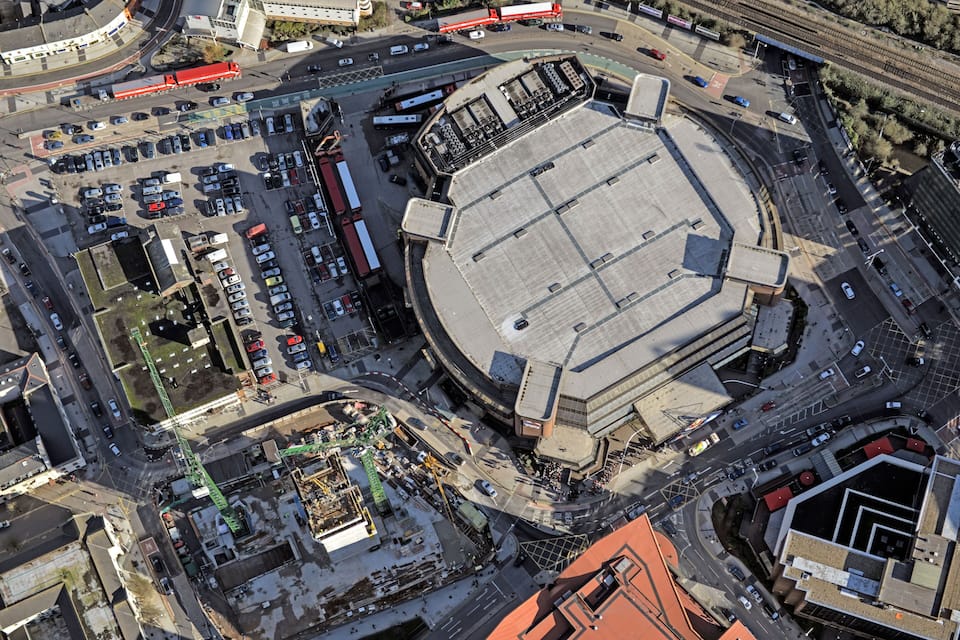 An aerial view of a stadium surrounded by parking lots and roads.