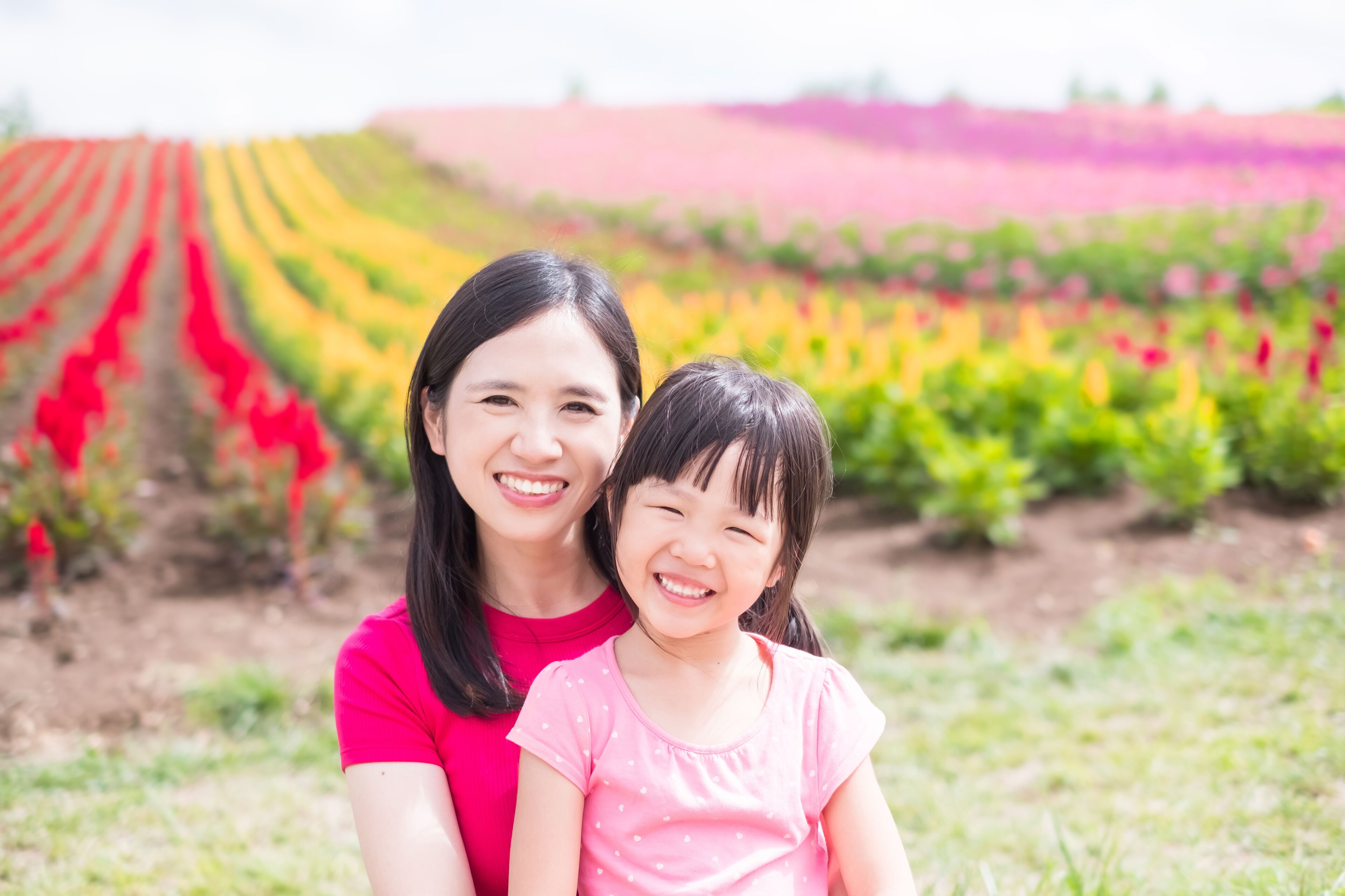 Una mujer y un niño en un campo lleno de flores de colores.