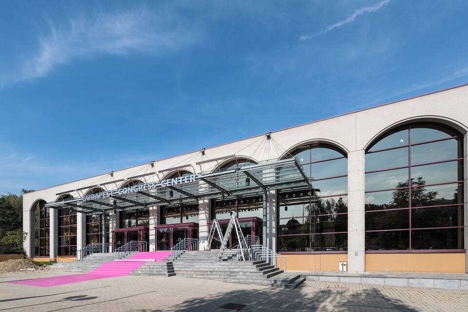 A modern building with arched windows and a covered entrance.