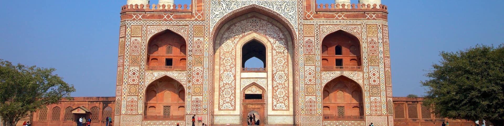 Un grand bâtiment somptueux, doté de quatre minarets et orné de motifs complexes en mosaïque.