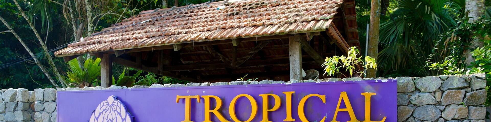 A sign for Tropical Spice Garden with a tropical flower design.