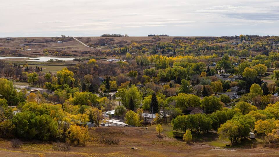 Aerial Panoramic view of a small Town in the Prairies during a vibrant sunny day in the Fall Season. Taken in Lumsden, Saskatchewan, Canada