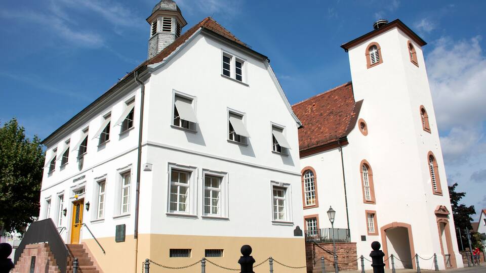A historic building with a white facade and a red-tiled roof.