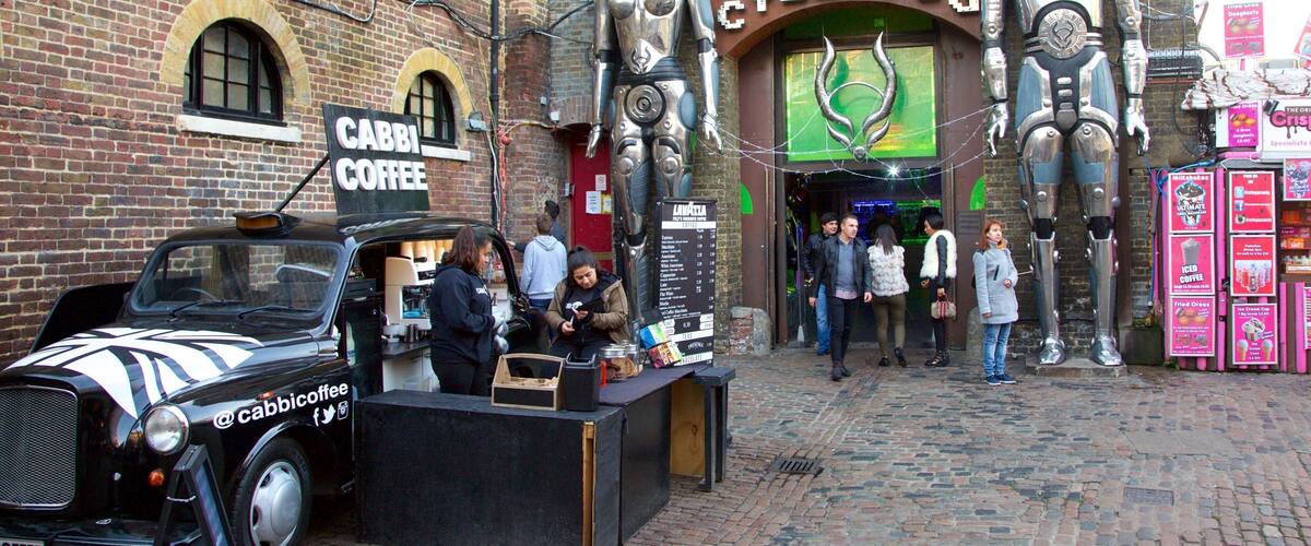 Camden Markets som inkluderar skyltar, en staty eller skulptur och marknader