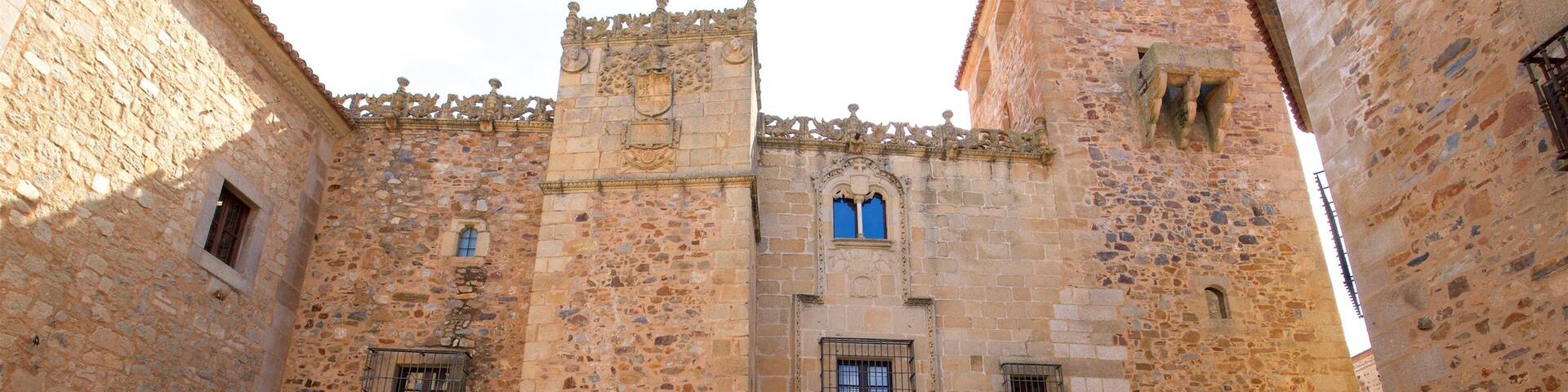 Un edificio histórico de piedra con ventanas arqueadas y una puerta central.