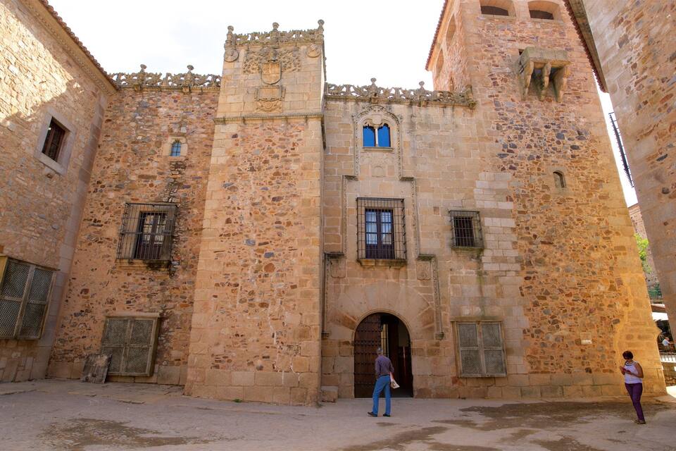 Un edificio histórico de piedra con ventanas arqueadas y una puerta central.
