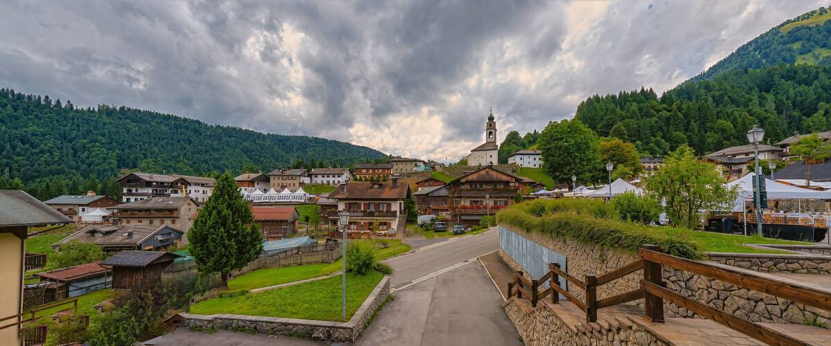 A village with traditional houses, a church, and a mountain backdrop.