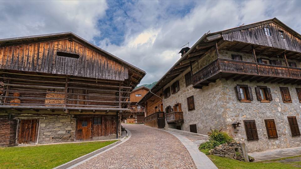 A rustic village with wooden houses and a cobblestone path.