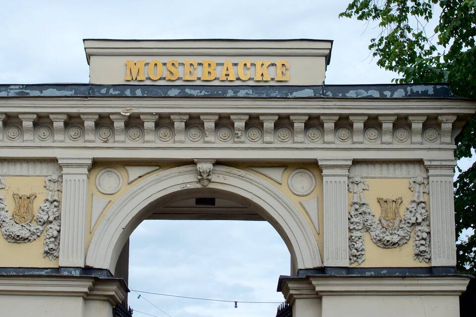 An ornate archway with the inscription "MUSEUMBAUKE" at the top.