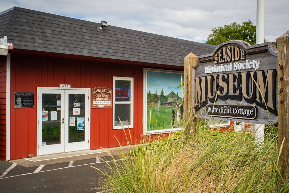 A red building with a sign for the Seaside Museum.