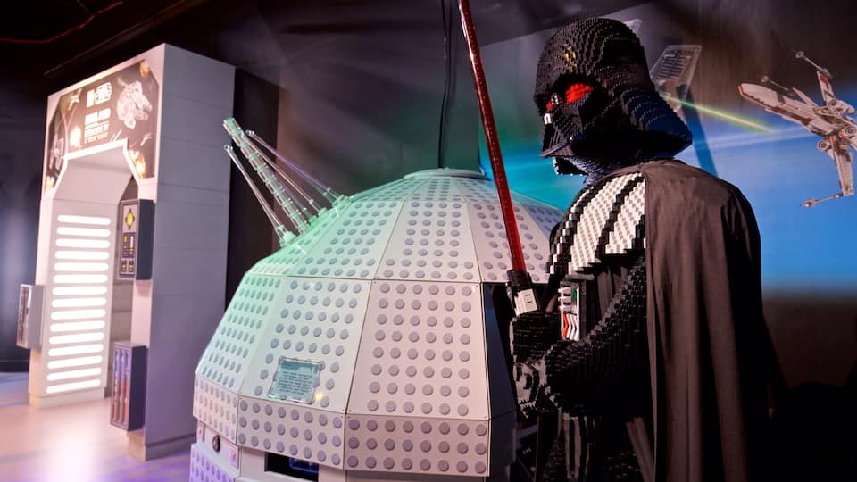 A LEGO Darth Vader figure next to a LEGO spaceship.