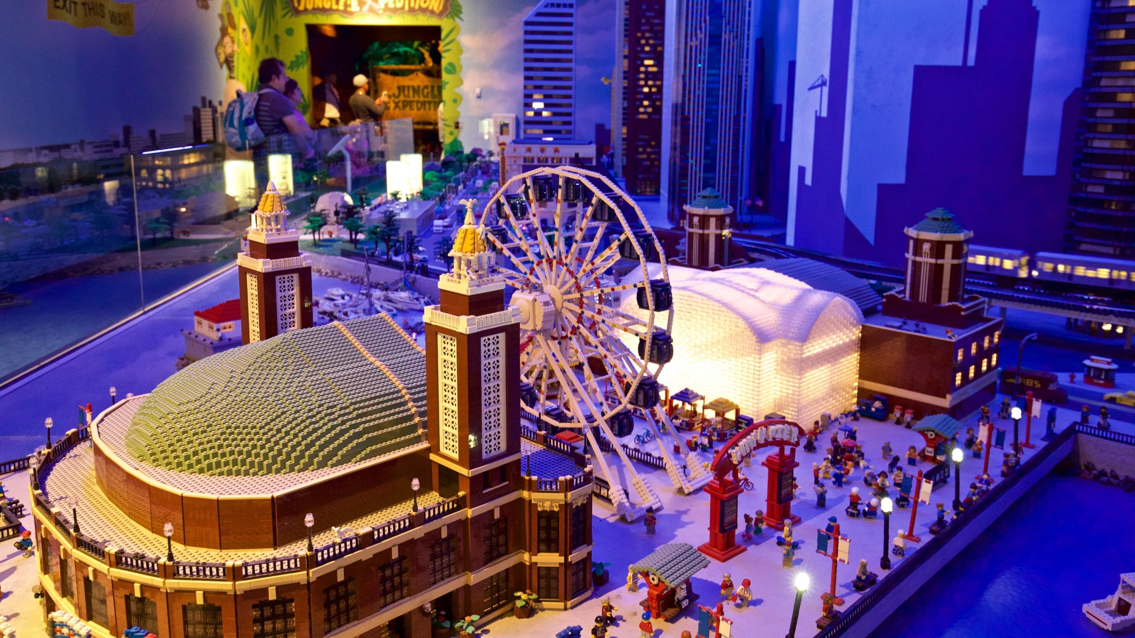 A LEGO cityscape with a large Ferris wheel, a stadium, and various buildings.
