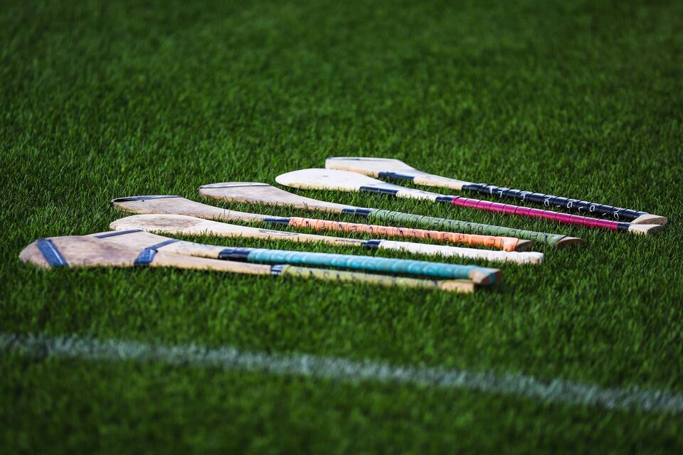 Een rij hurleys op een grasveld.
