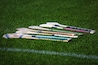 A bunch of camogie ash hurleys lie in the grass