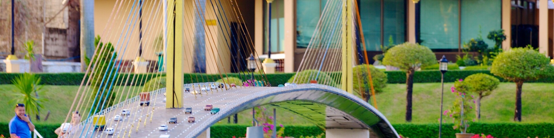 A model of a bridge with cars and a building in the background.