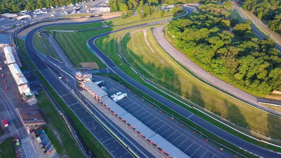 An aerial view of a race track surrounded by lush greenery.