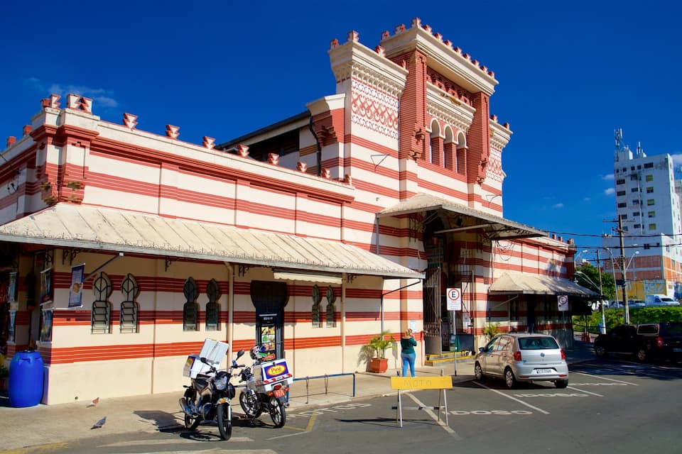 Un edifici històric amb franges vermelles i blanques, un vestíbul cobert i motocicletes aparcades.