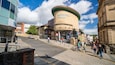 The Millennium Forum building with a curved entrance and a sign above it.