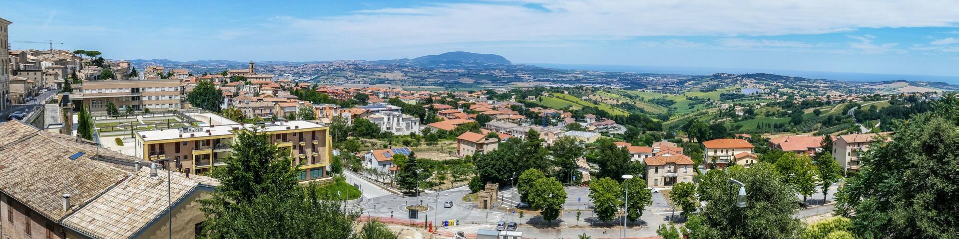 A panoramic view of a town with a prominent hill in the background.