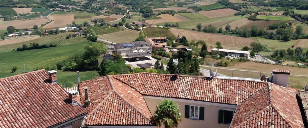 A rural landscape with terraced fields, a village, and rolling hills.