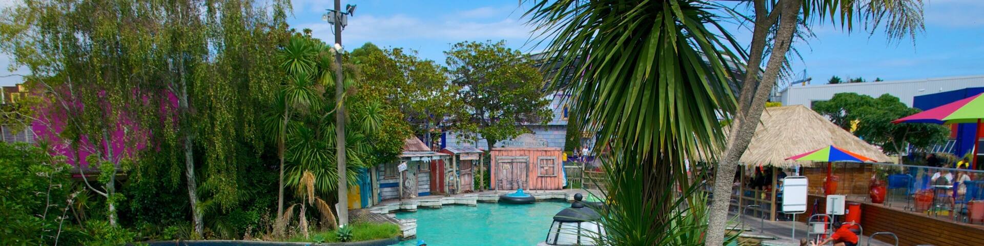 A water ride with colorful rubber boats, surrounded by lush greenery and a clear blue pool.