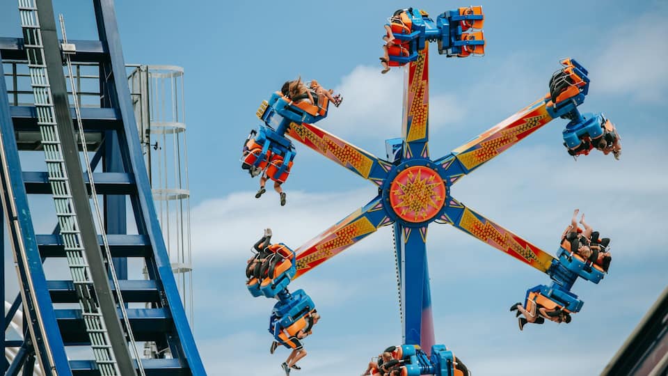 Rainbow\'s End featuring rides as well as a small group of people