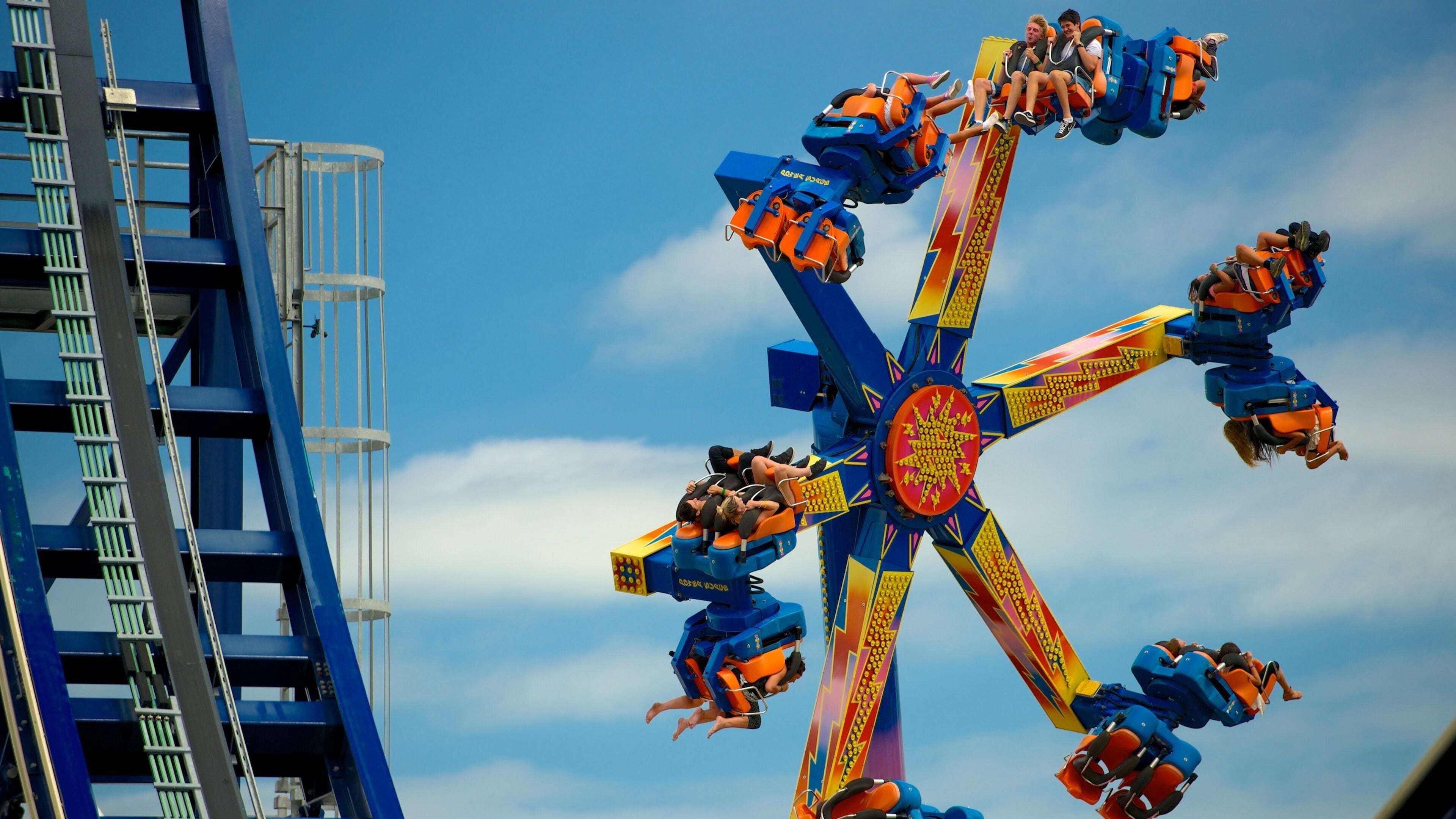 Atracción giratoria de feria con asientos de colores y un centro.