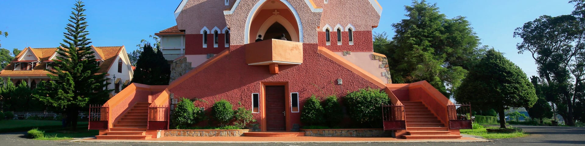 Una iglesia con un techo triangular característico y un ventanal circular.
