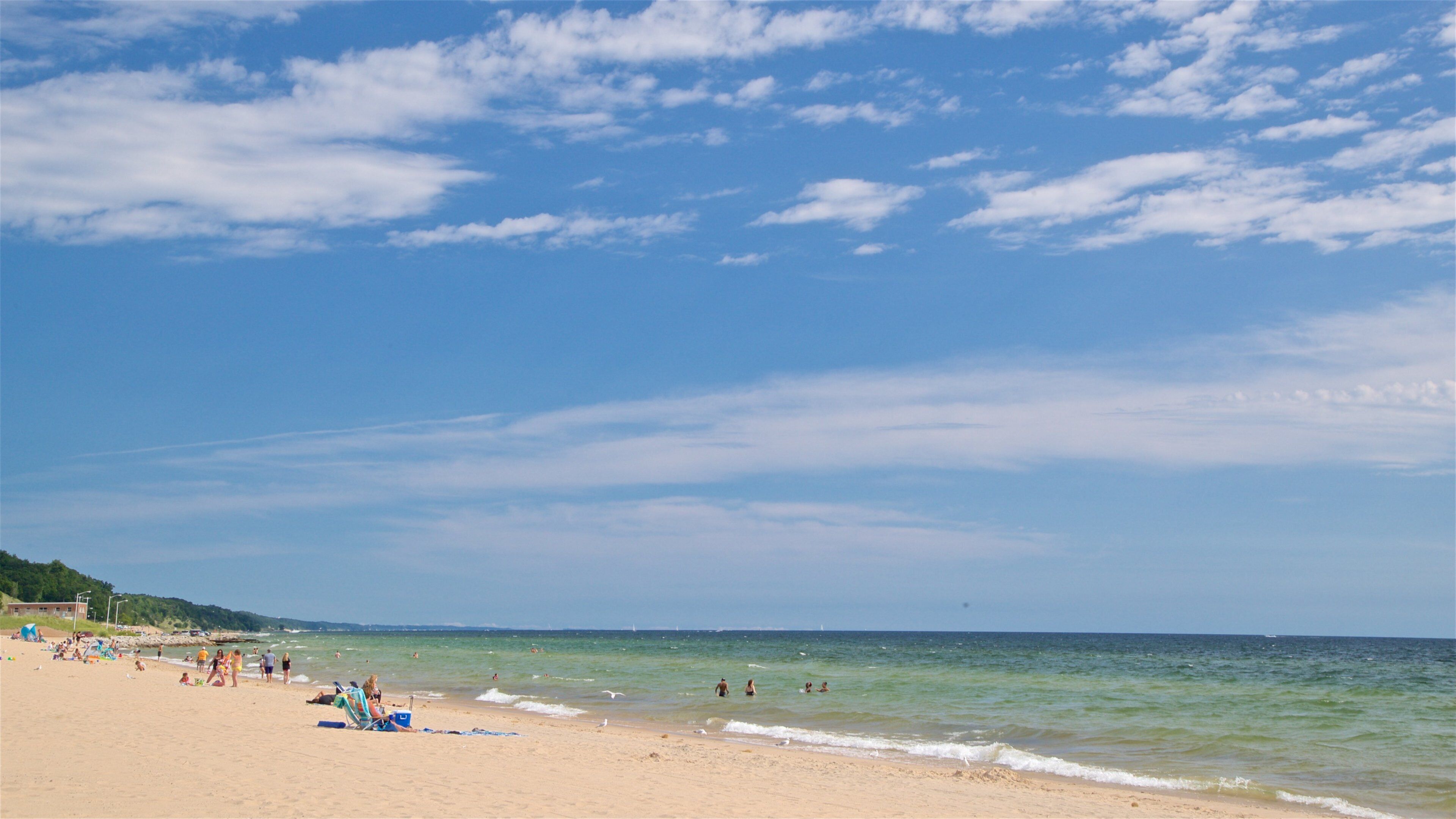 Pere Marquette Park Beach featuring a sandy beach and general coastal views as well as a small group of people