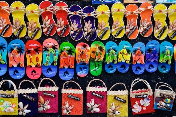 Un assortiment de tongs et de sacs de plage colorés, tous arborant la marque « BORACAY ».