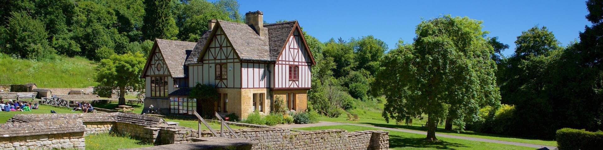 Chedworth Roman Villa mostrando um lago, uma casa e elementos de patrimônio