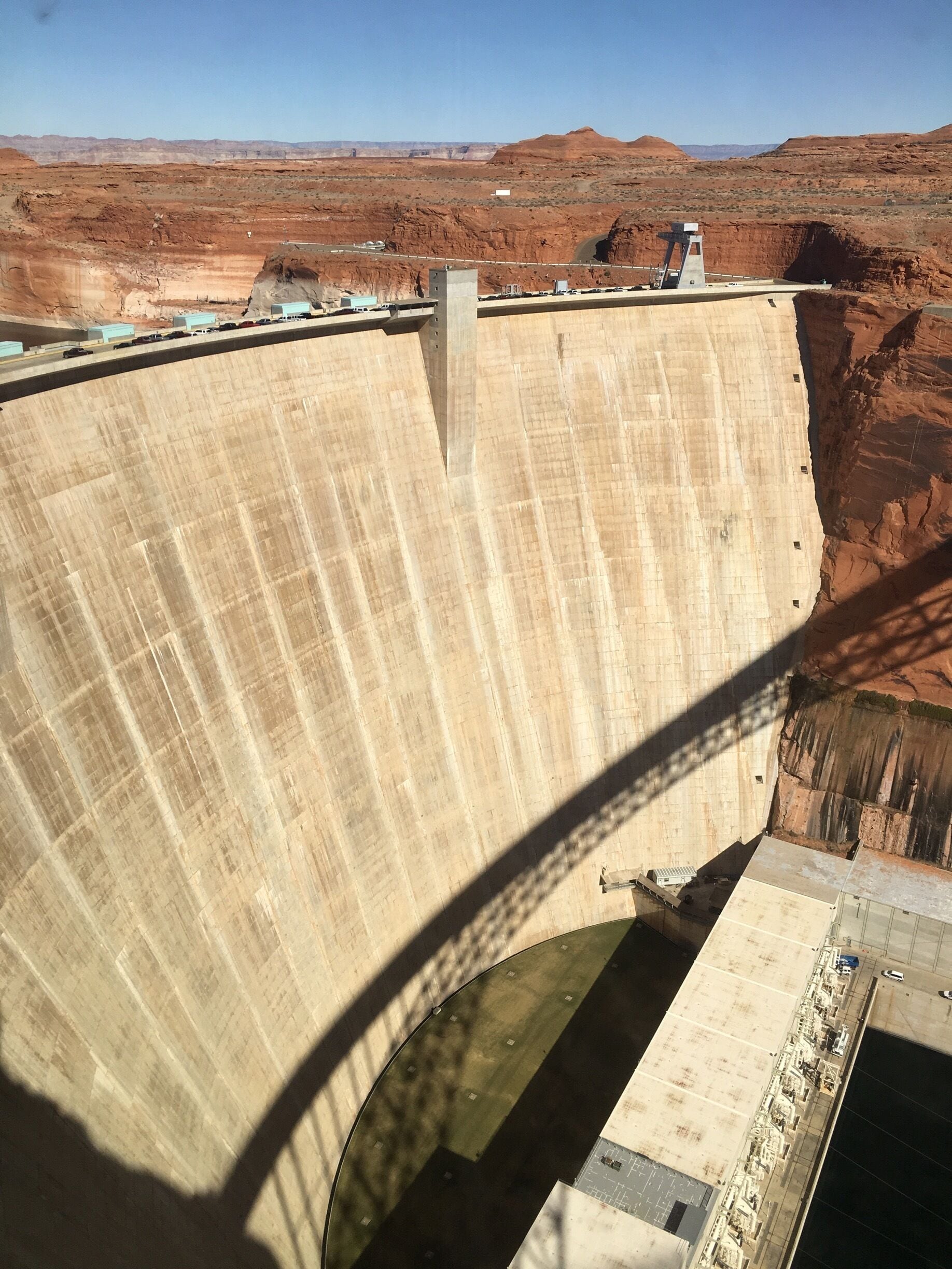 Glen Canyon Dam is a concrete arch dam on the Colorado River in northern Arizona in the United States, near the town of Page. The dam was built to provide hydroelectricity and flow regulation from the upper Colorado River Basin to the lower. Its reservoir is called Lake Powell, and is the second-largest artificial lake in the country, extending upriver well into Utah. The dam is named for Glen Canyon, a colorful series of gorges, most of which now lies under the reservoir.