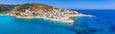 Lovely greek fishing village of Armenistis in a quiet summer morning. Port with local beach in transparent clear water at Ikaria, Greece