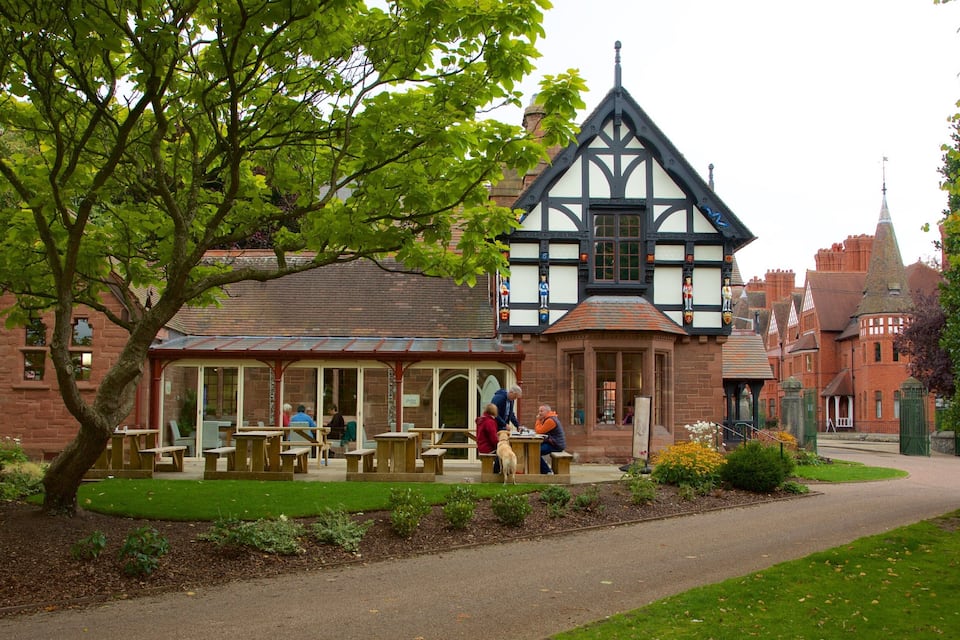 A traditional Tudor-style building with a garden and outdoor seating area.