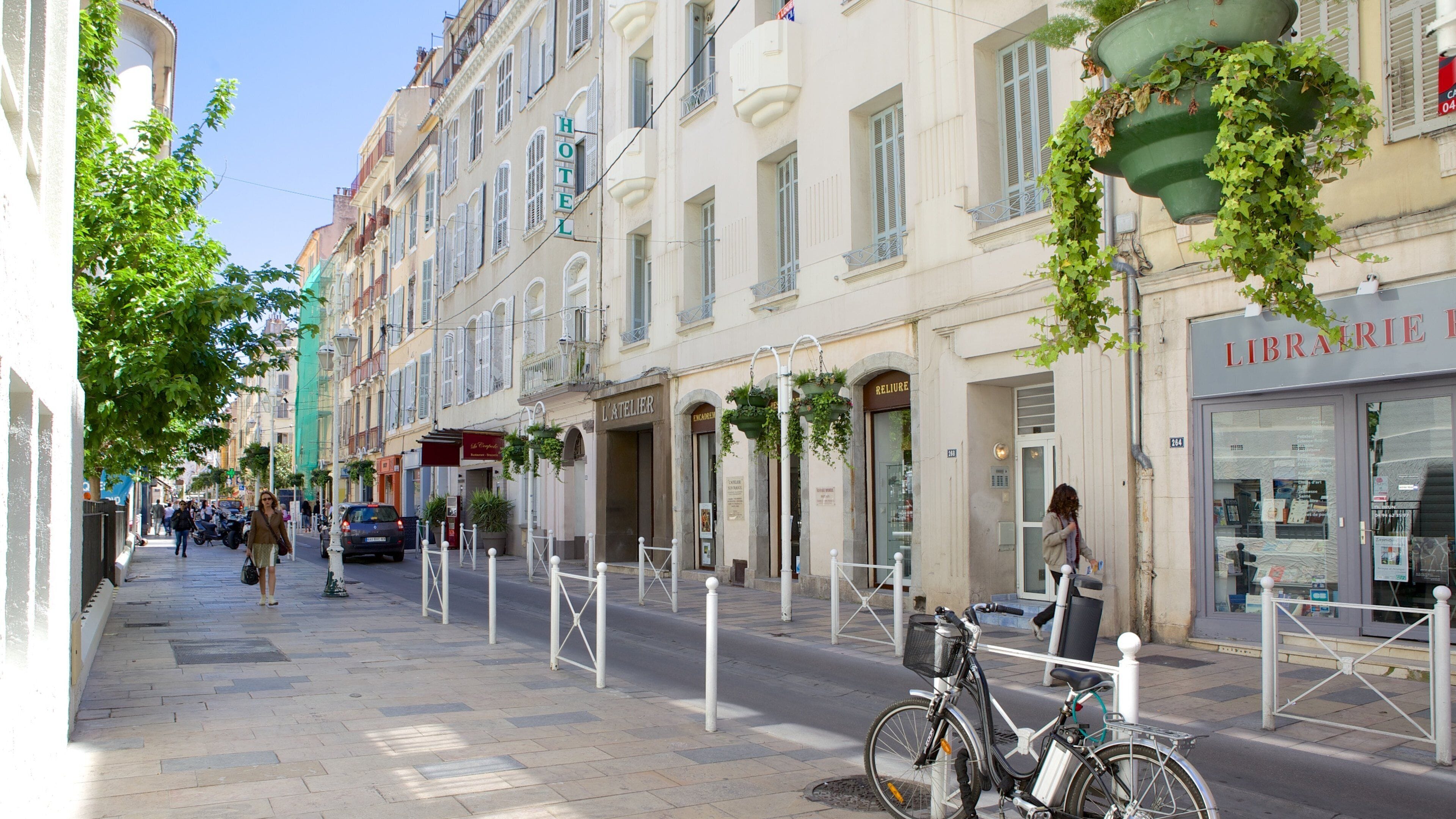 Rua europeia com edifícios históricos, uma livraria e uma bicicleta.