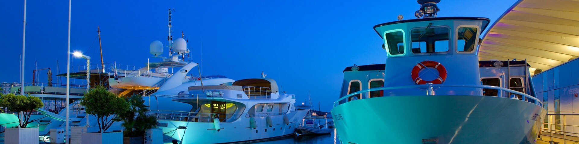 Un puerto deportivo al atardecer con varios yates amarrados.