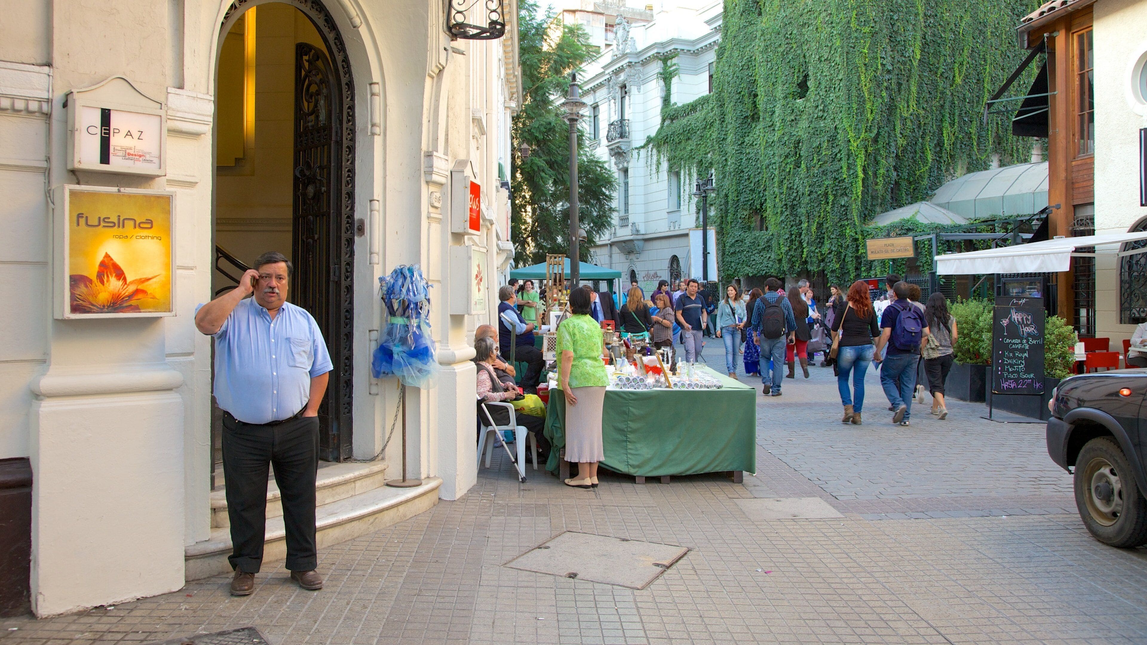 A busy street with people walking, a market stall, and a building with a sign 'CEP AZ'.
