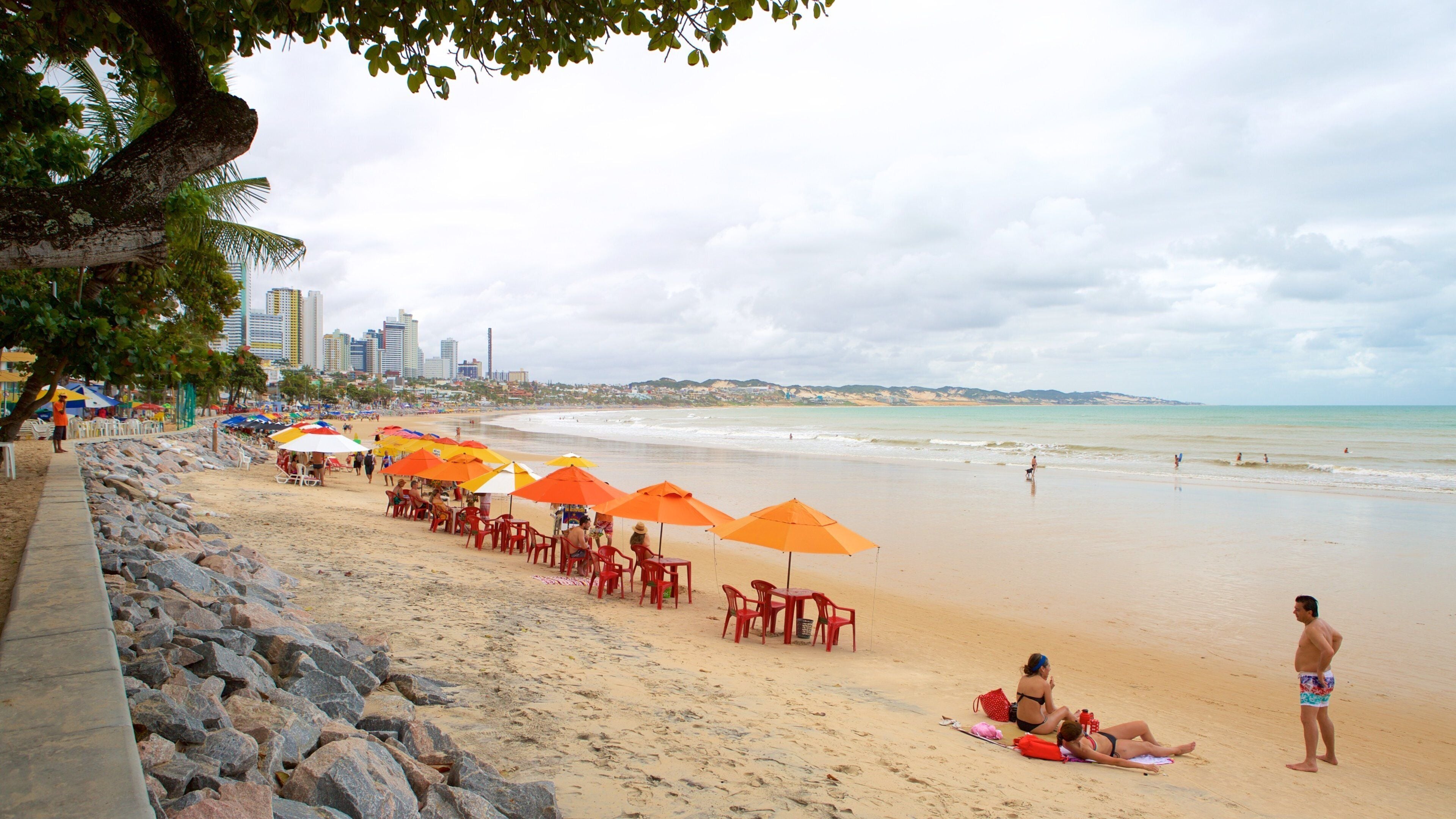 Ponta Negra strand som inkluderer kyst og strand i tillegg til en liten gruppe med mennesker