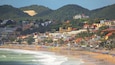 Ponta Negra Beach showing a coastal town, swimming and a sandy beach
