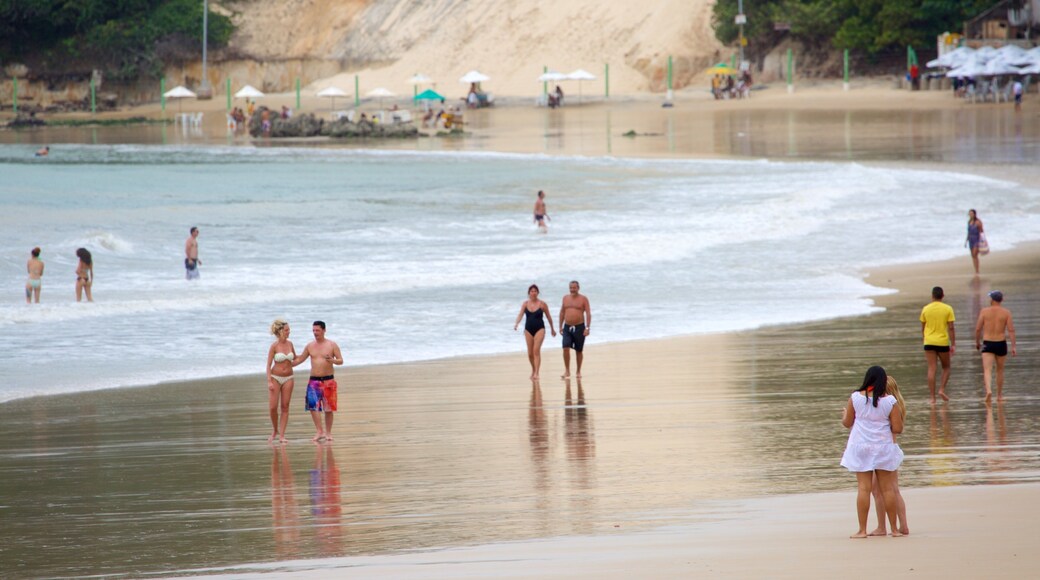 Ponta Negra Beach which includes a coastal town and a sandy beach as well as a couple