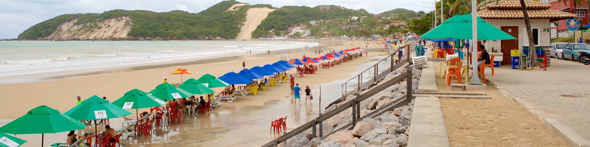 Playa de Ponta Negra mostrando una playa de arena y vistas generales de la costa y también un pequeño grupo de personas
