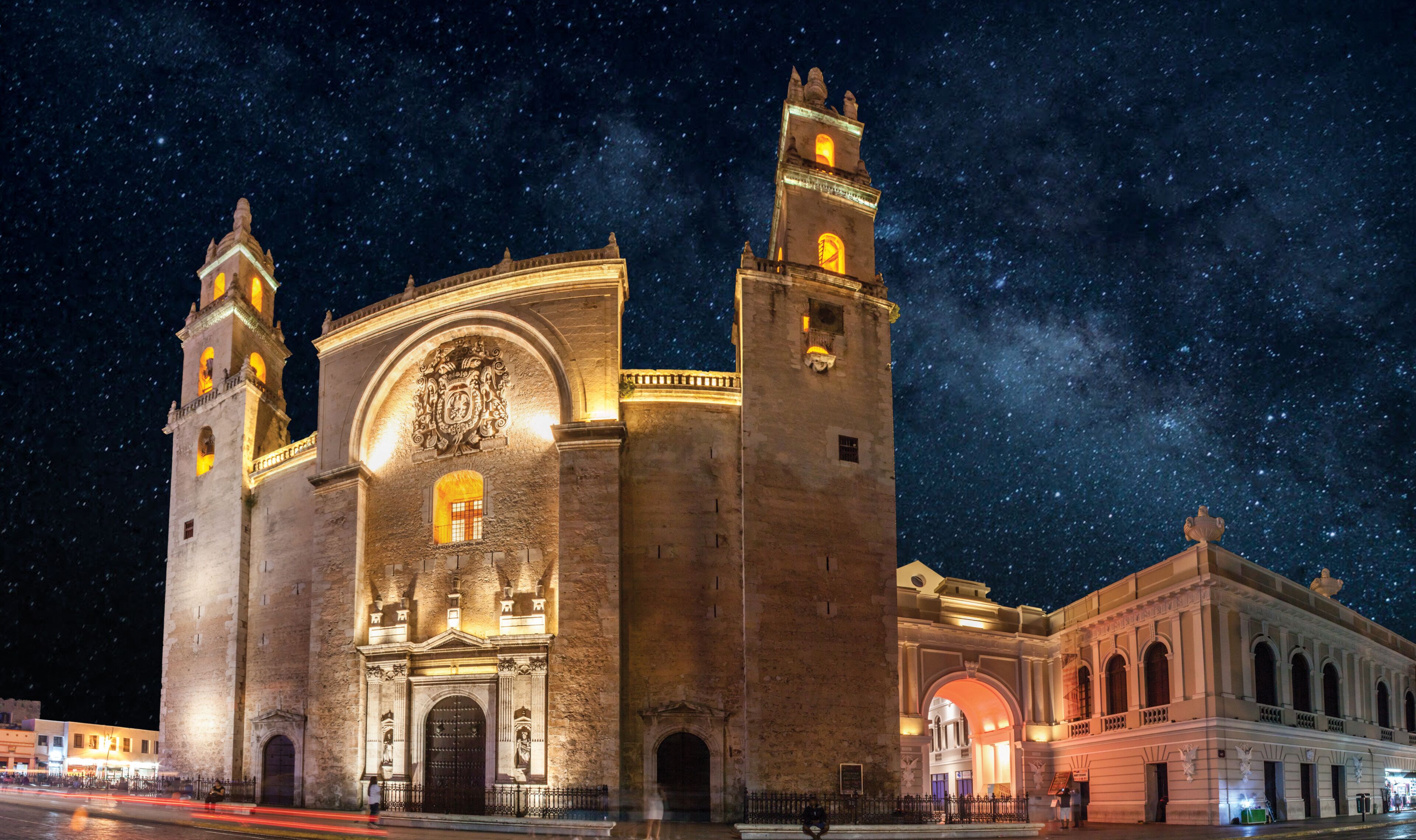 A historic building with two towers, ornate arches, and a starry night sky.