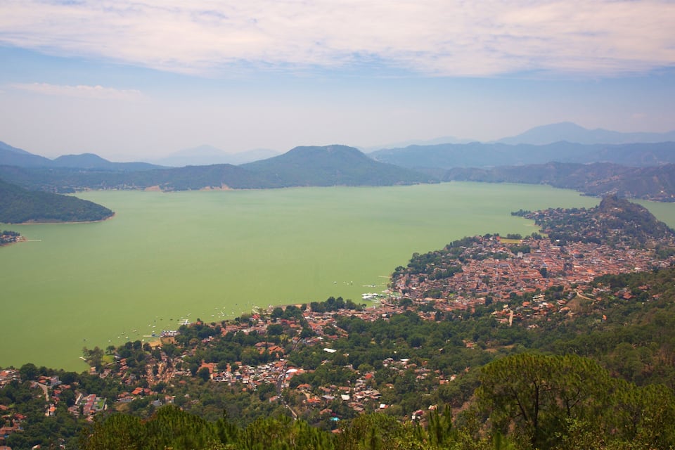 Um lago rodeado por montanhas e uma cidade.