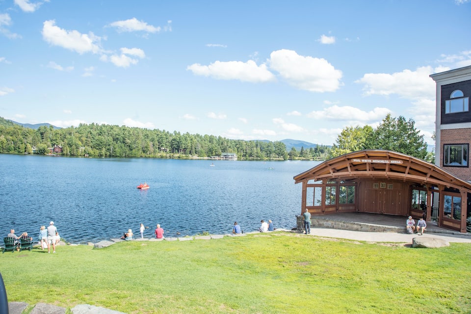 A lake with a wooden pavilion and a building labeled "Paul White Memorial Shell."