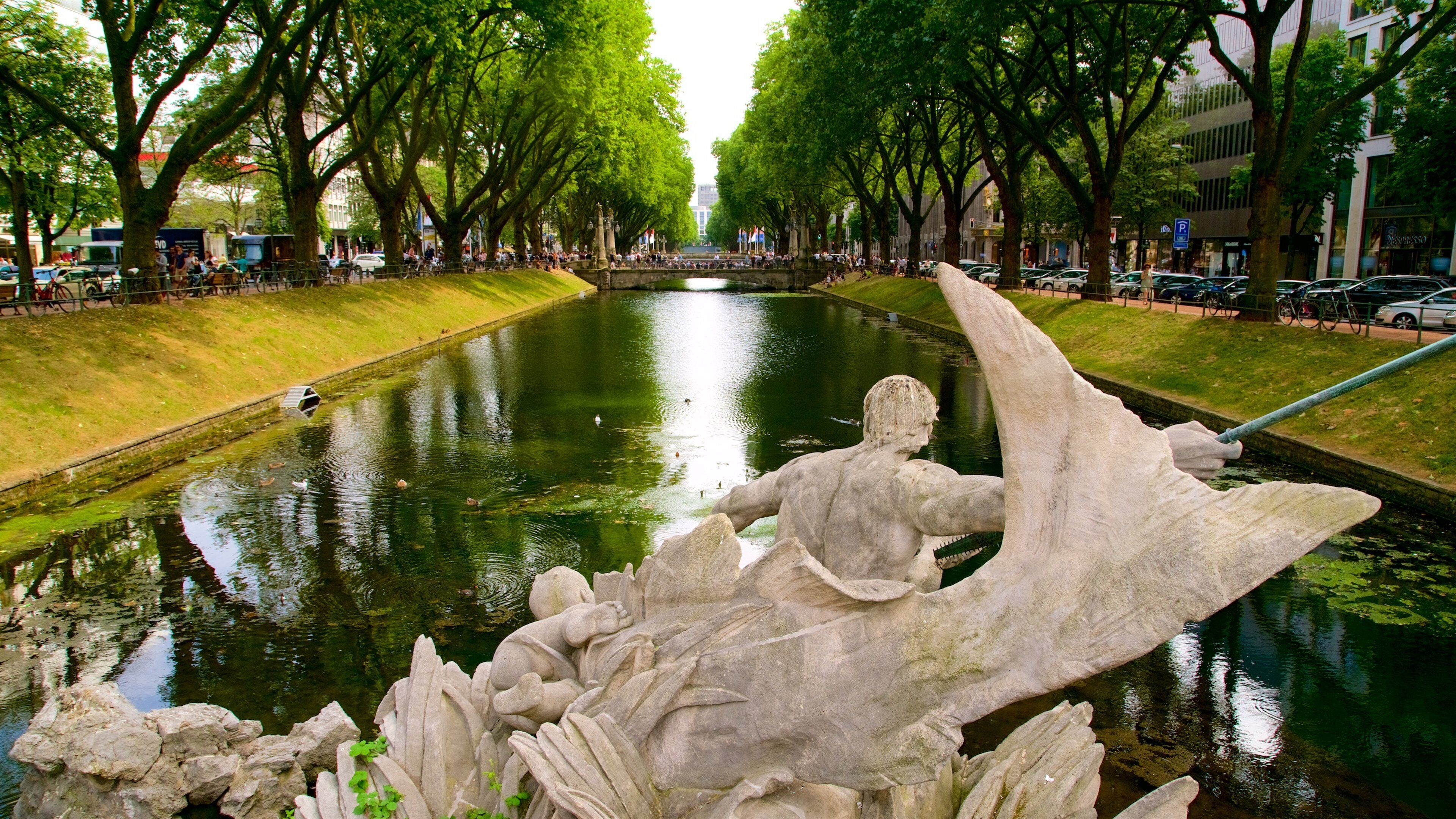 A canal with a stone sculpture of a winged figure.