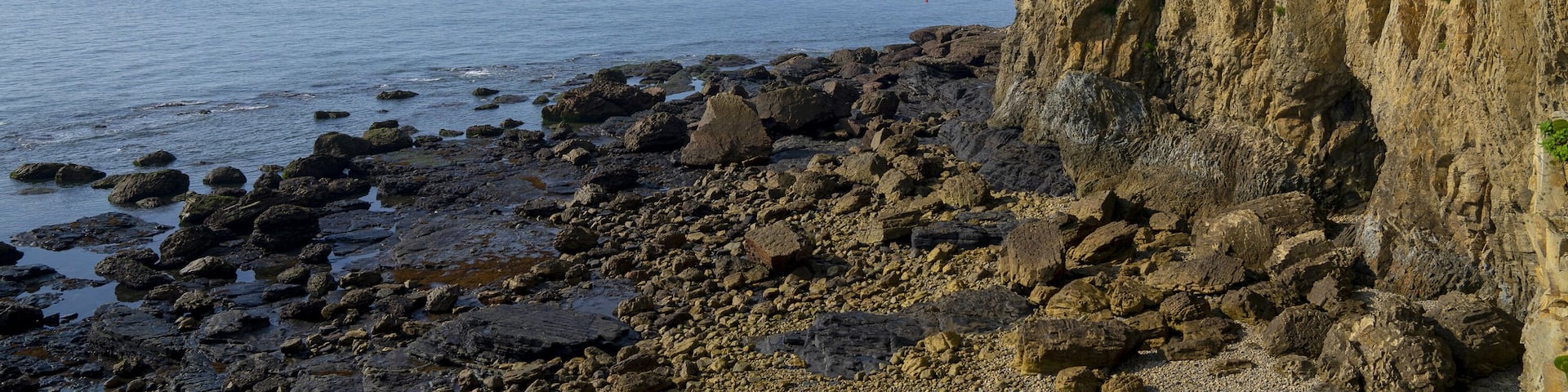 Byeonsan-myeon, Buan-gun, Jeollabuk-do, South Korea - July 11, 2018: Summer view of rocks at low tide at Chaeseokgang Cliff of Byeonsan Peninsula against horizon