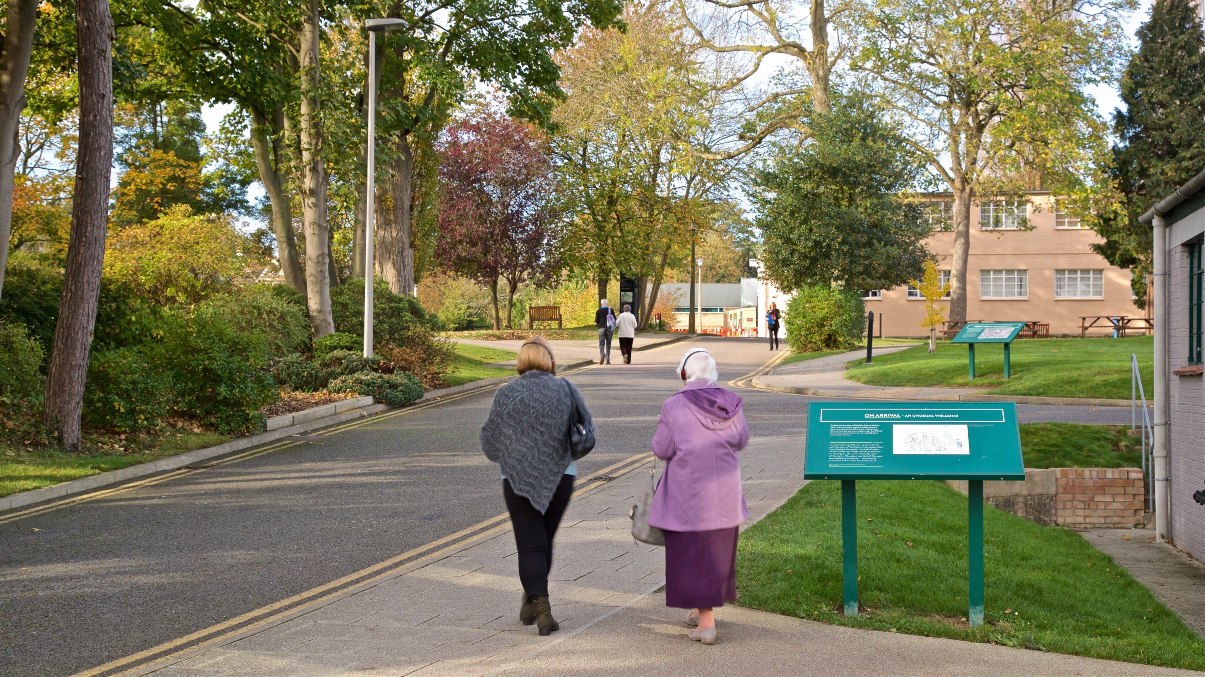 Bletchley Park mostrando señalización y un jardín y también una pareja